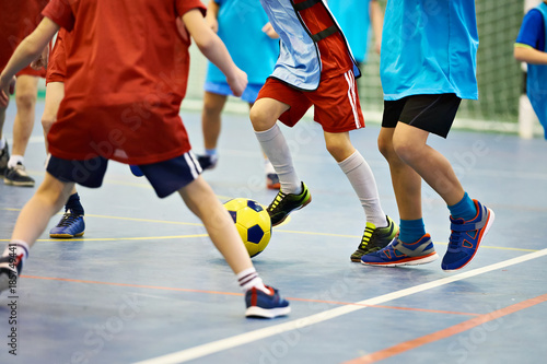 Children playing soccer indoors photo