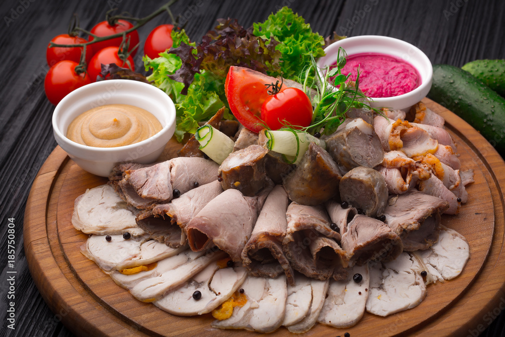 Meat appetizer antipasto on black wooden background Meat appetizer antipasto on black wooden background