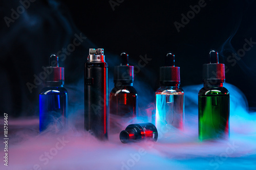 jars of liquids for vape in multi-colored smoke