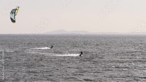 panning shot of two kite surfers at brighton beach, victoria-recorded at 1080 60fps photo