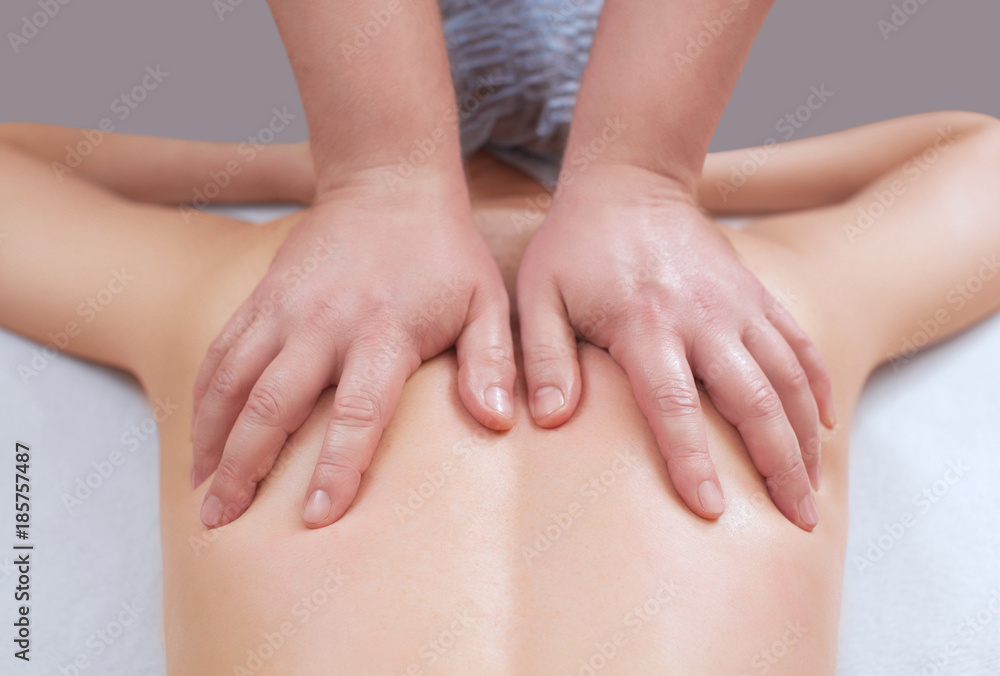The masseur makes a massage on the back of the patient in the beauty salon. Medical care for the body. The masseur makes a massage on the back of the patient in the beauty salon. Medical care for the body.