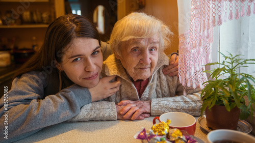 Portrait of an elderly woman with her adult granddaughter.