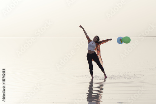 motivation or hope concept  follow your dream and inspiration  girl with balloons at sunset  