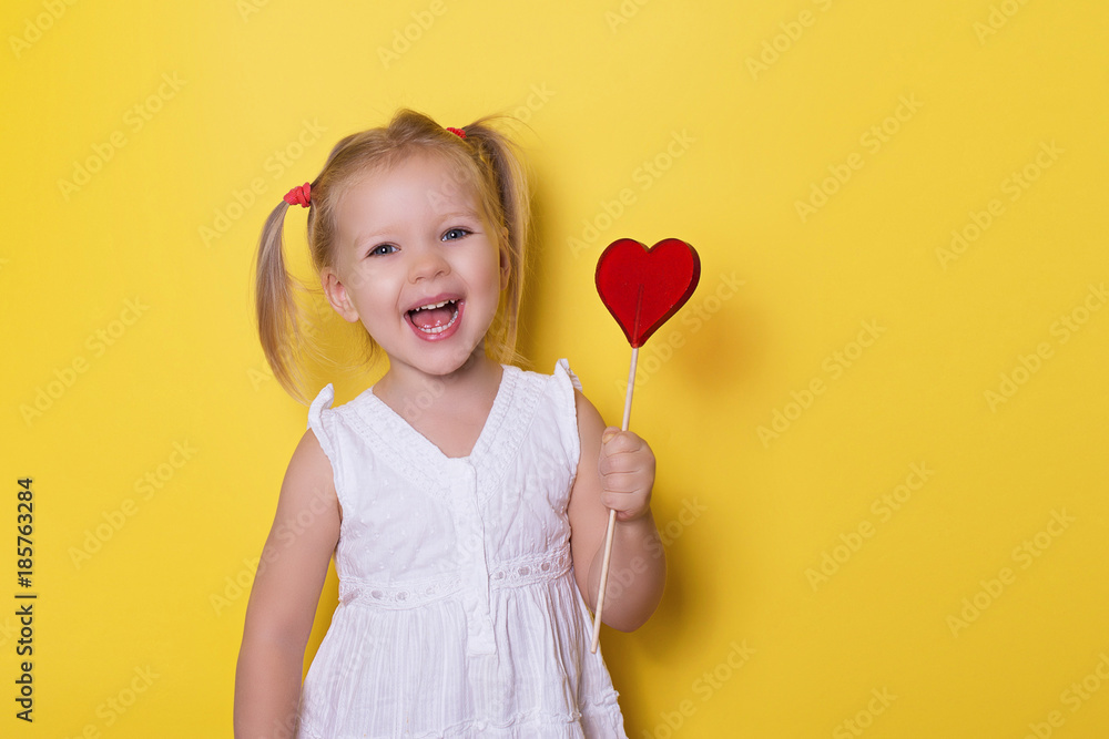 Pretty girl with red bright lollipop candy on yellow background valentines day holiday love theme