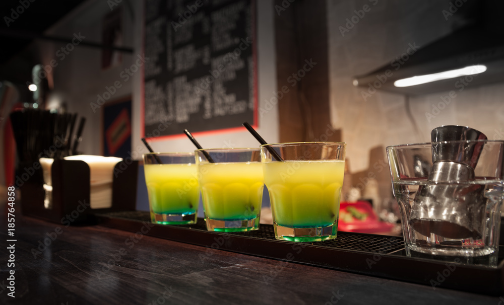 three glasses of cocktails are on the bar three glasses of cocktails are on the bar