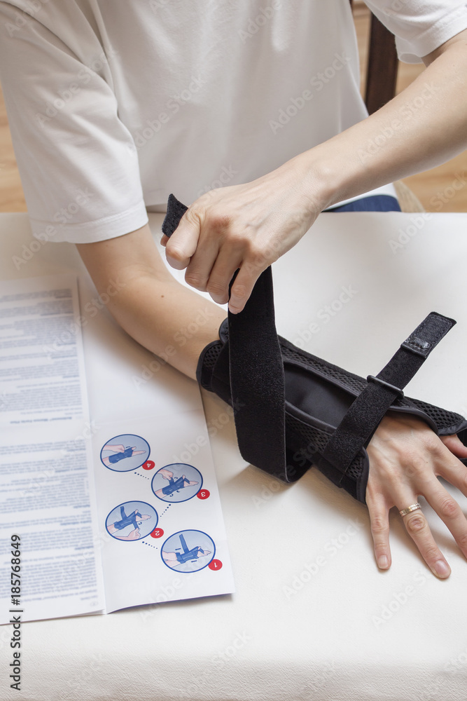 Kobieta zakłada stabilizator nadgarstka korzystając z instrukcji.