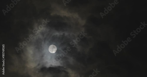 Full moon at night with moving clouds