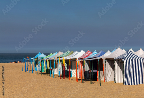 Praia da Nazare beach in Nazare,  Portugal, covered with the summertime beach tents.