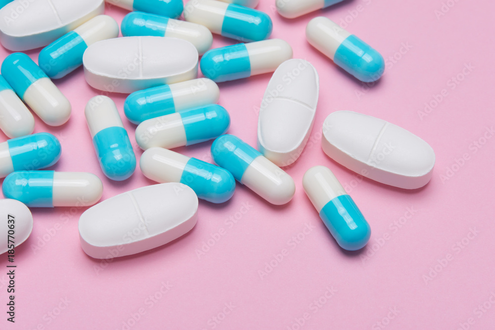 closed up of tablets and capsules of medicine on pink background closed up of tablets and capsules of medicine on pink background