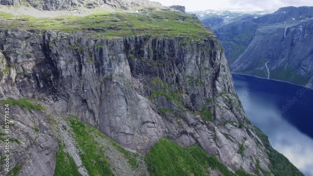 Amazing view of nature Norwegian. Slow camera flight from left to right. Fly over high mountains with snowy peaks, dense green grass, mountain river. Typical nature of Norway, Europe in nice weather Amazing view of nature Norwegian. Slow camera flight from left to right. Fly over high mountains with snowy peaks, dense green grass, mountain river. Typical nature of Norway, Europe in nice weather