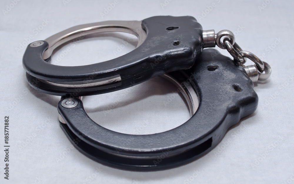 A pair of handcuffs on a white background A pair of handcuffs on a white background