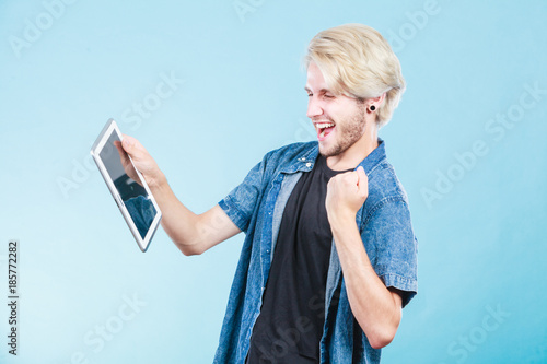 Trendy young guy using tablet computer