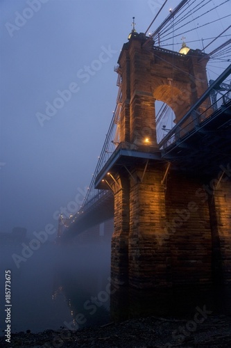 cincinnati, ohio and covington kentucky riverfront and bridges in the fog on misty day at dusk