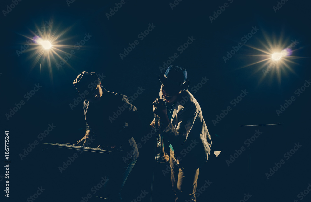 Musician Duo band playing a keyboard and singing on black background with spot light and lens flare, musical concept