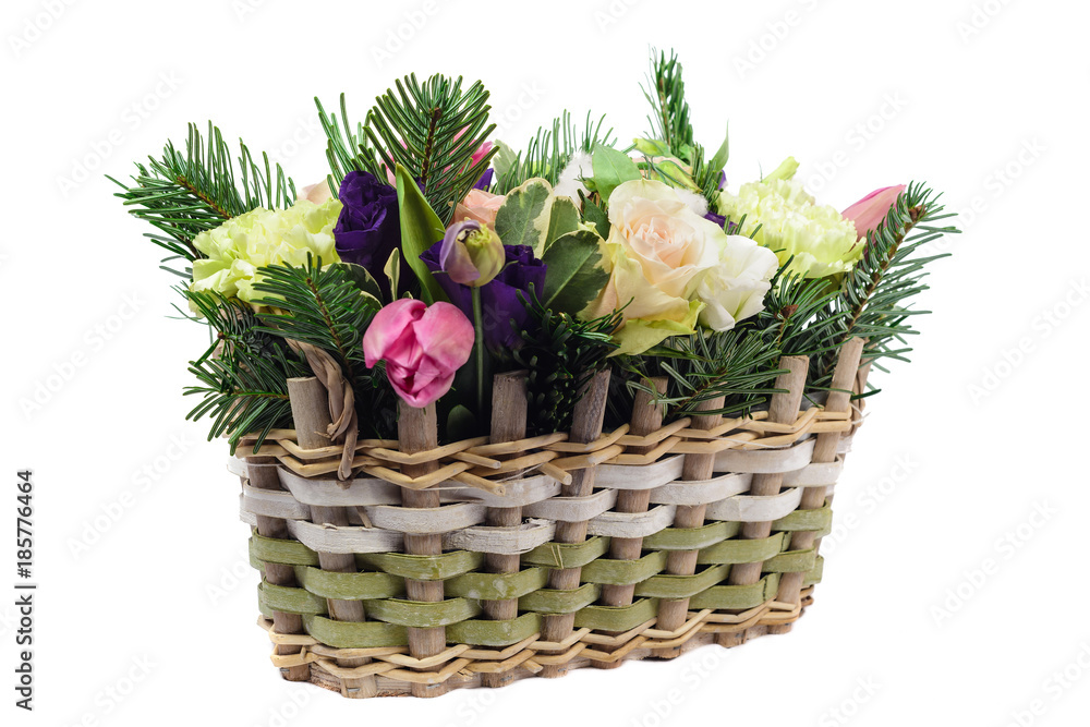a beautiful bouquet of roses, lulips and carnations in a wicker basket. isolated on white