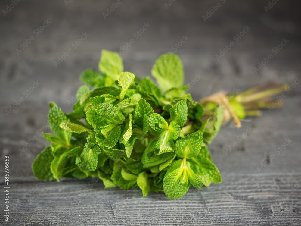 Bunch mint, tied with a rough rope on dark wooden table. The concept of healthy eating. Bunch mint, tied with a rough rope on dark wooden table. The concept of healthy eating.