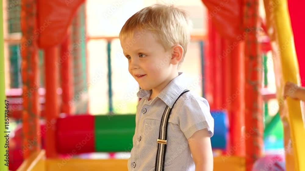 Close-up of small boy in shirt and suspenders plays on the Playground with plastic balls, throwing them at the camera. Slow motion. Close-up of small boy in shirt and suspenders plays on the Playground with plastic balls, throwing them at the camera. Slow motion.