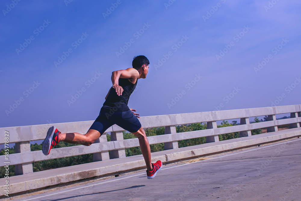 Man running sprinting on road. Fit male fitness runner during outdoor workout. Man running sprinting on road. Fit male fitness runner during outdoor workout.
