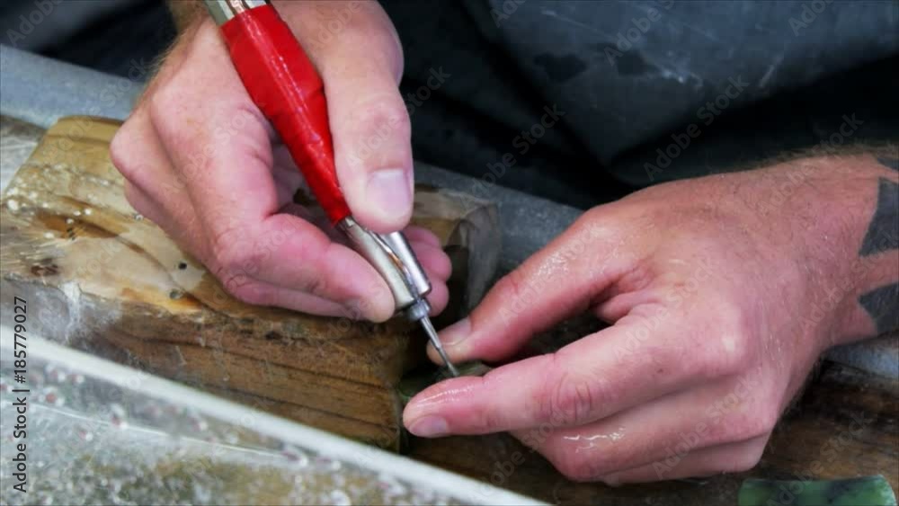 a man carves a piece of jade in a factory at hokitika, new zealand a man carves a piece of jade in a factory at hokitika, new zealand
