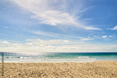 Warm blue sea. White clouds. Light Sand