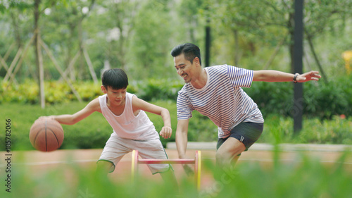 Canvas Print Asian father & son playing basketball in garden in morning