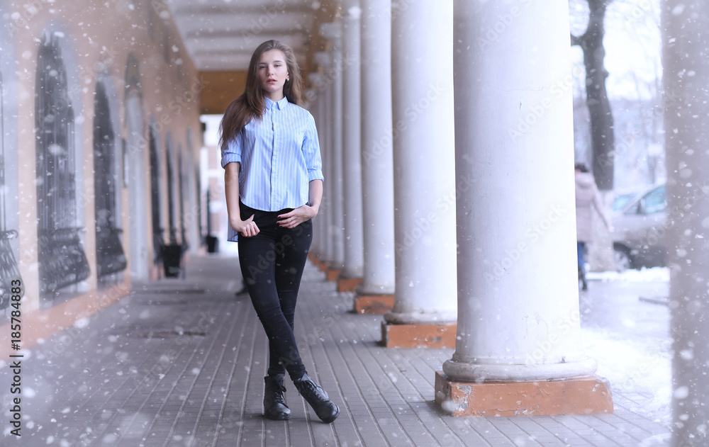 Young girl outdoors in winter. Model girl posing outdoors on a w Young girl outdoors in winter. Model girl posing outdoors on a w
