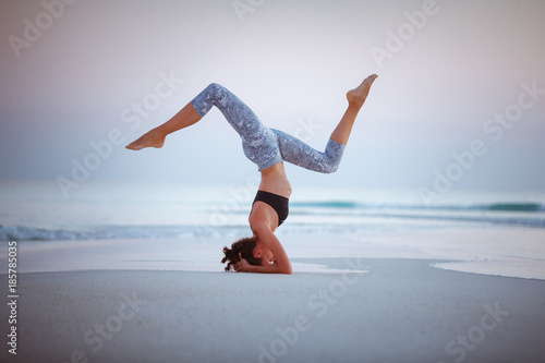 Summer yoga session on a beautiful golden beach of Maldives yoga tour, Salamba Sirsasana - supported headstand