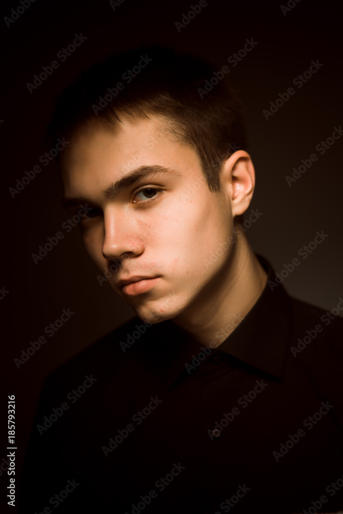 Fototapeta premium młody chłopak na ciemnym tle studio