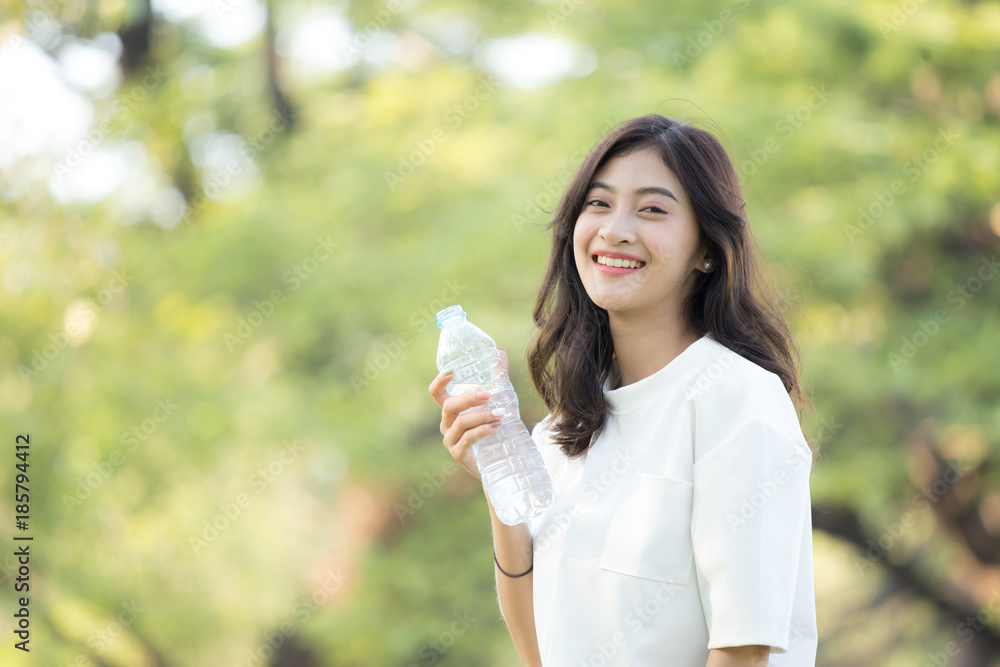 Attractive Asian Woman drinking water at garden. Woman with health care concept. Attractive Asian Woman drinking water at garden. Woman with health care concept.