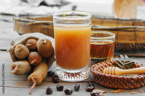 Tamarind and tamarind juice with honey on wooden background
 photo