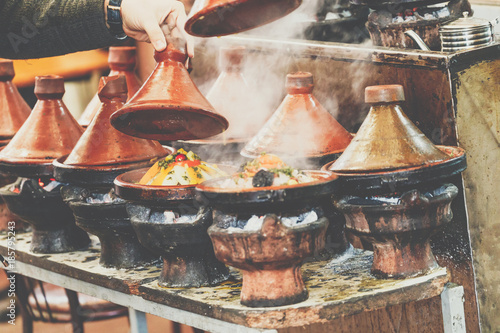 Cooking of meat in traditional Moroccan ceramic tajine dish, Marrakesh, Morocco