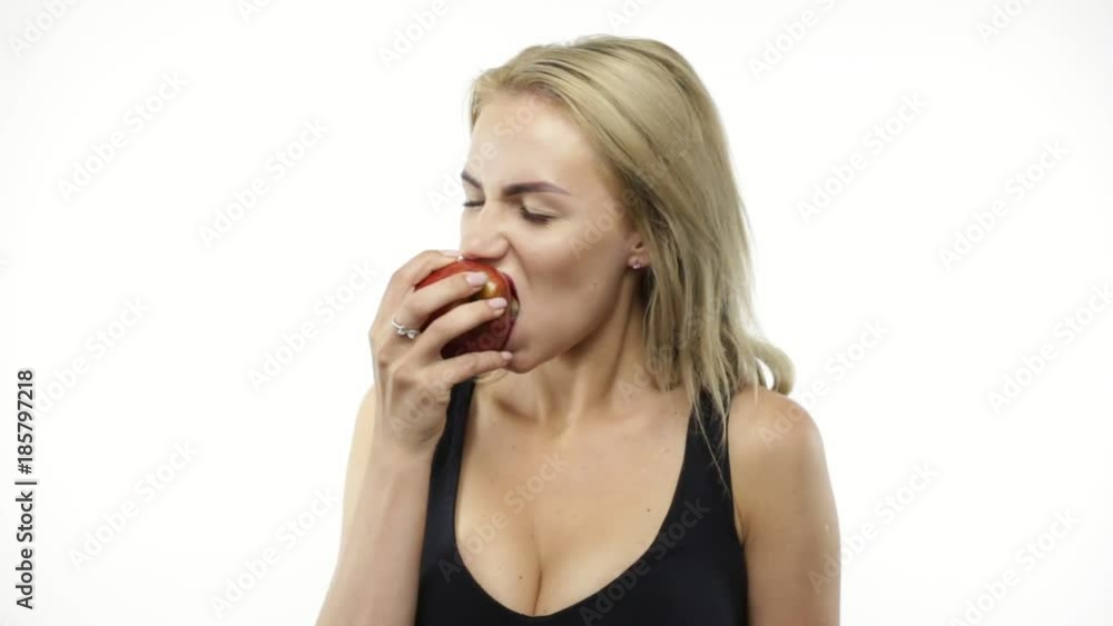 Passionate woman eating red apple on white Passionate woman eating red apple on white