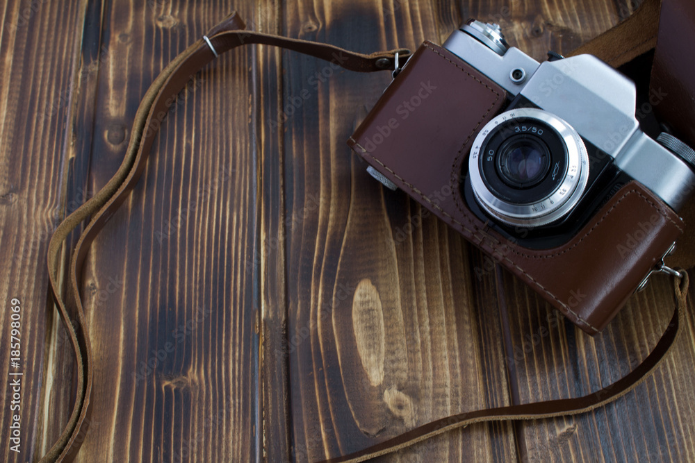 Old camera on the wooden background