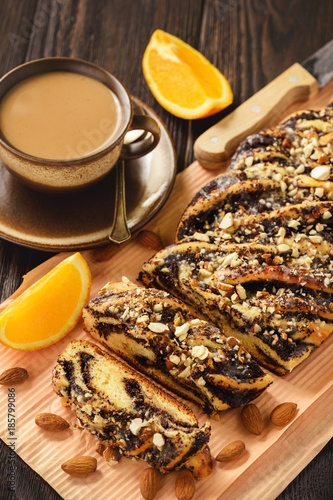 Homemade poppy seed braided bread on wooden background. photo