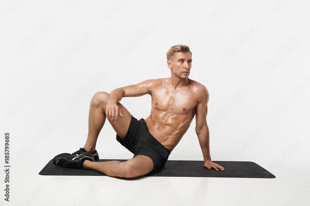 Handsome sportive man posing on mat