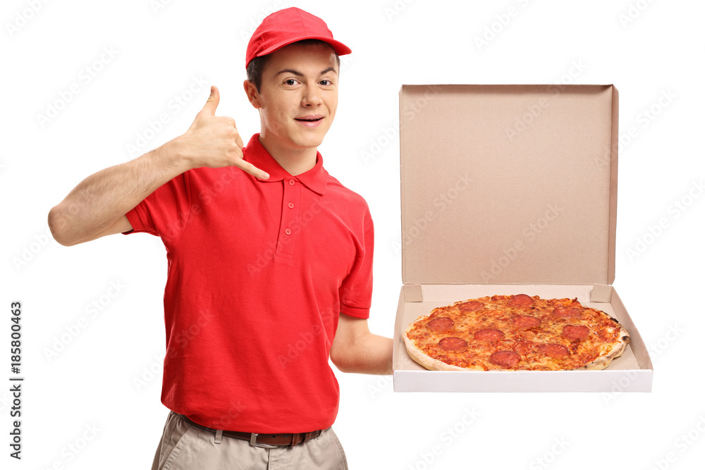 Teenage pizza delivery boy holding a pizza box and making a call me gesture Teenage pizza delivery boy holding a pizza box and making a call me gesture