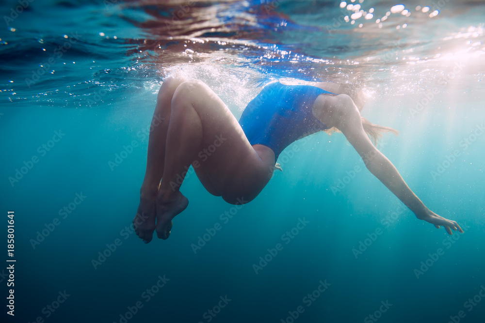 Underwater woman portrait with blue bikini in ocean.