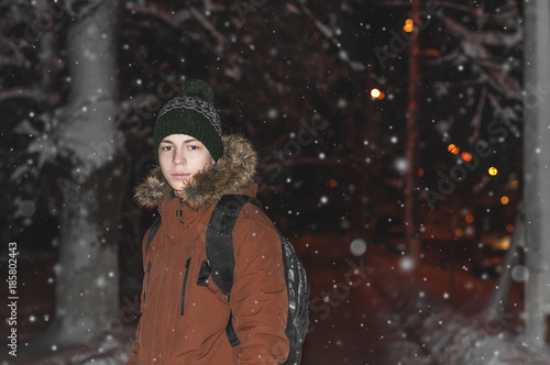 young man on a city street during a snowfall