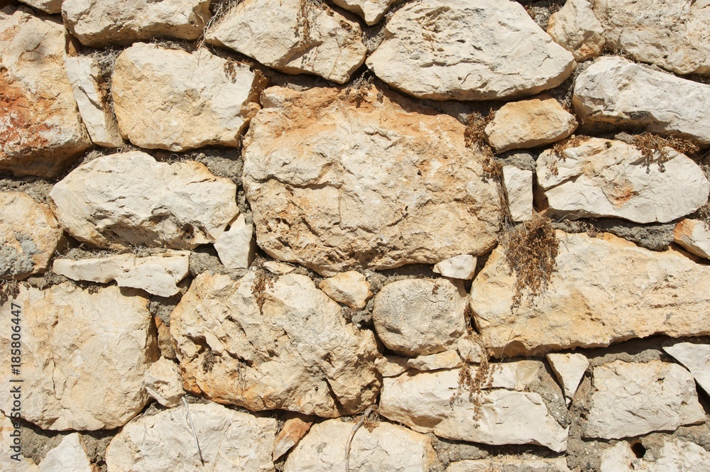Fototapeta premium Genoese fortress wall fragment. Old stonewall. Textured background. Rocks and concrete.