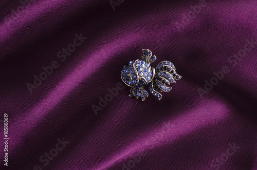 brooch fish with diamonds isolated on silk