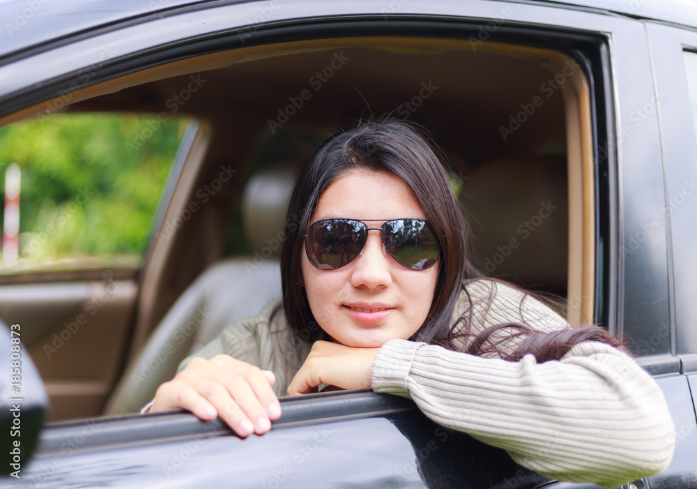 Asian woman protrudes from the window of the car
