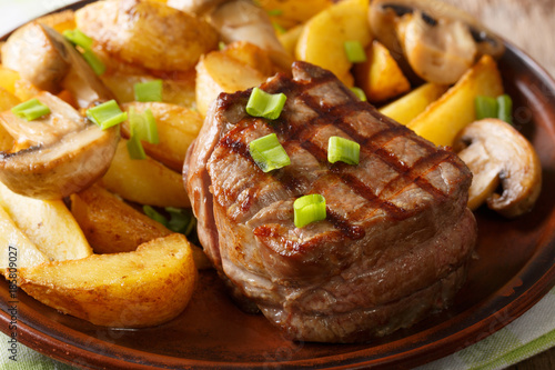 Grilled fillet mignon with potatoes and mushrooms close-up. horizontal