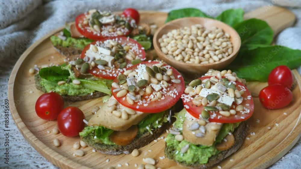 Sprinkle Sesame On Vegan Avocado Toasts Closeup. 4K. Sprinkle Sesame On Vegan Avocado Toasts Closeup. 4K.