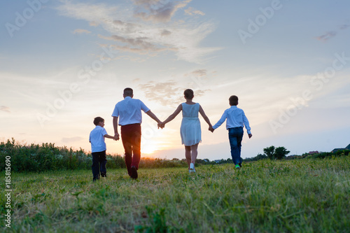 Happy family on the background of the sunset