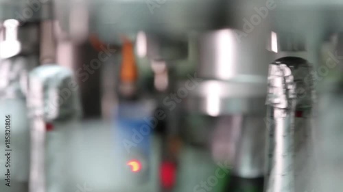 Champagne at the factory. Bottles filled with champagne are moving along the conveyor, close-up. Change the focus between the foreground and background. Ambient sound at clip.