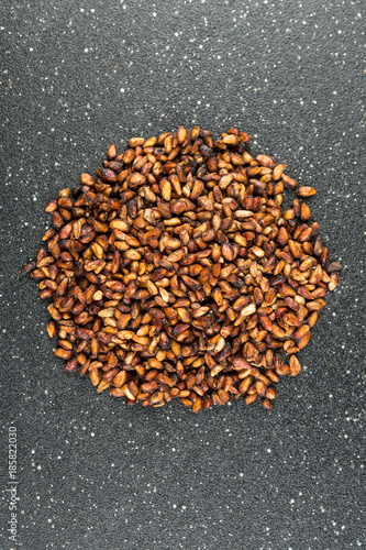 Pile of dried pomegranate seeds isolated on a black background photo