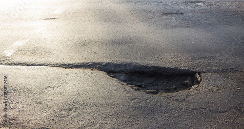Waterfilled pothole on asphalted road
