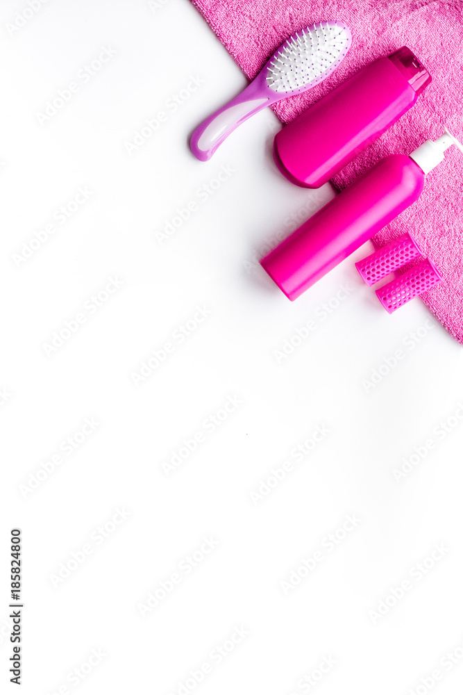 Basic hair care in bathroom. Comb, shampoo, spray, curlers, towel on white background top view copyspace Basic hair care in bathroom. Comb, shampoo, spray, curlers, towel on white background top view copyspace