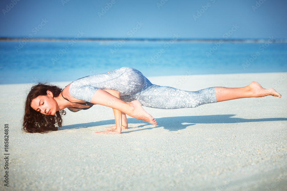 Φωτογραφία Summer yoga session on a beautiful golden beach of Eka Pada Koundinyasana I or P