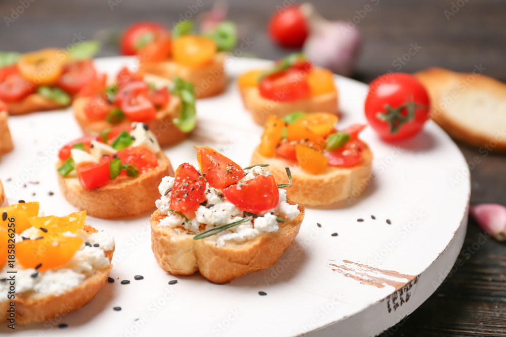 Tasty bruschettas with tomatoes on wooden board, closeup Tasty bruschettas with tomatoes on wooden board, closeup